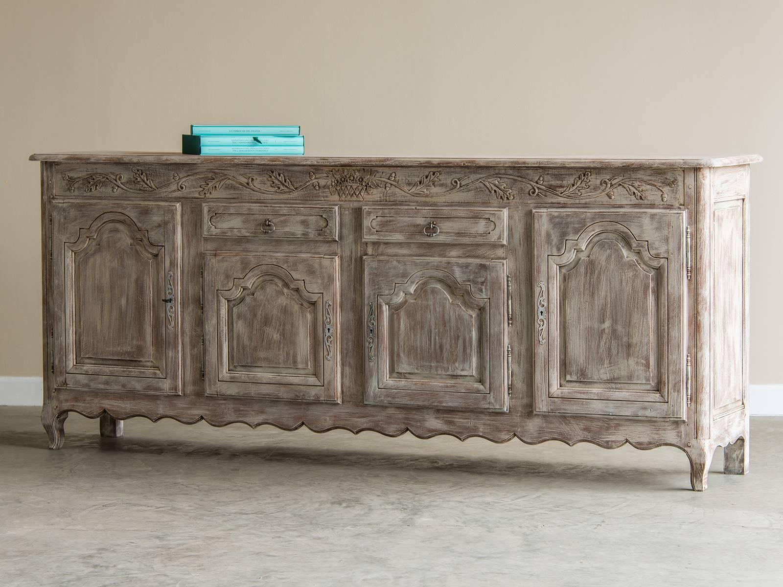 The beautiful detail on this buffet includes an enchanting floral and leaf swag that extends from side to side above the cabinet doors and beneath the serving surface. All of the cabinet doors feature a recessed panel with a moulded edge that throws
