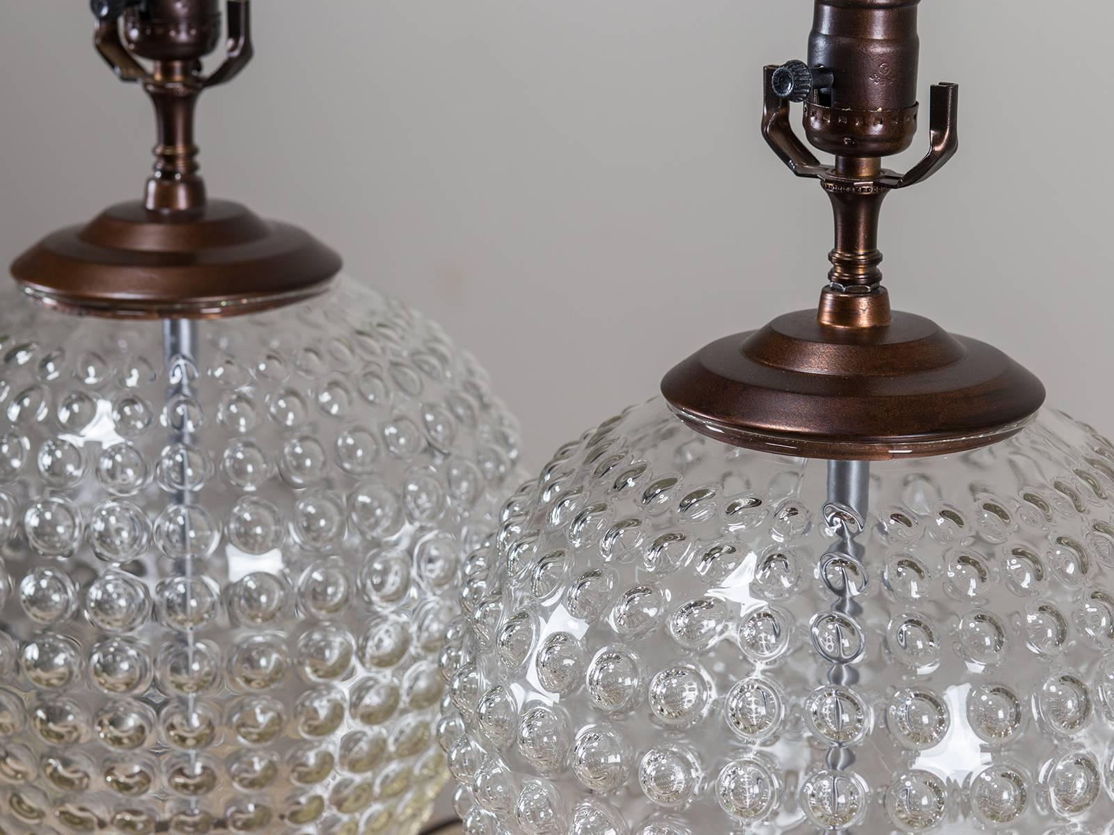 A pair of hand blown vintage French glass vessels with a distinctive hobnail pattern mounted with a copper/bronze color metal base and cover as lamps and rewired for American electricity. The beautiful manner in which light is reflected by the