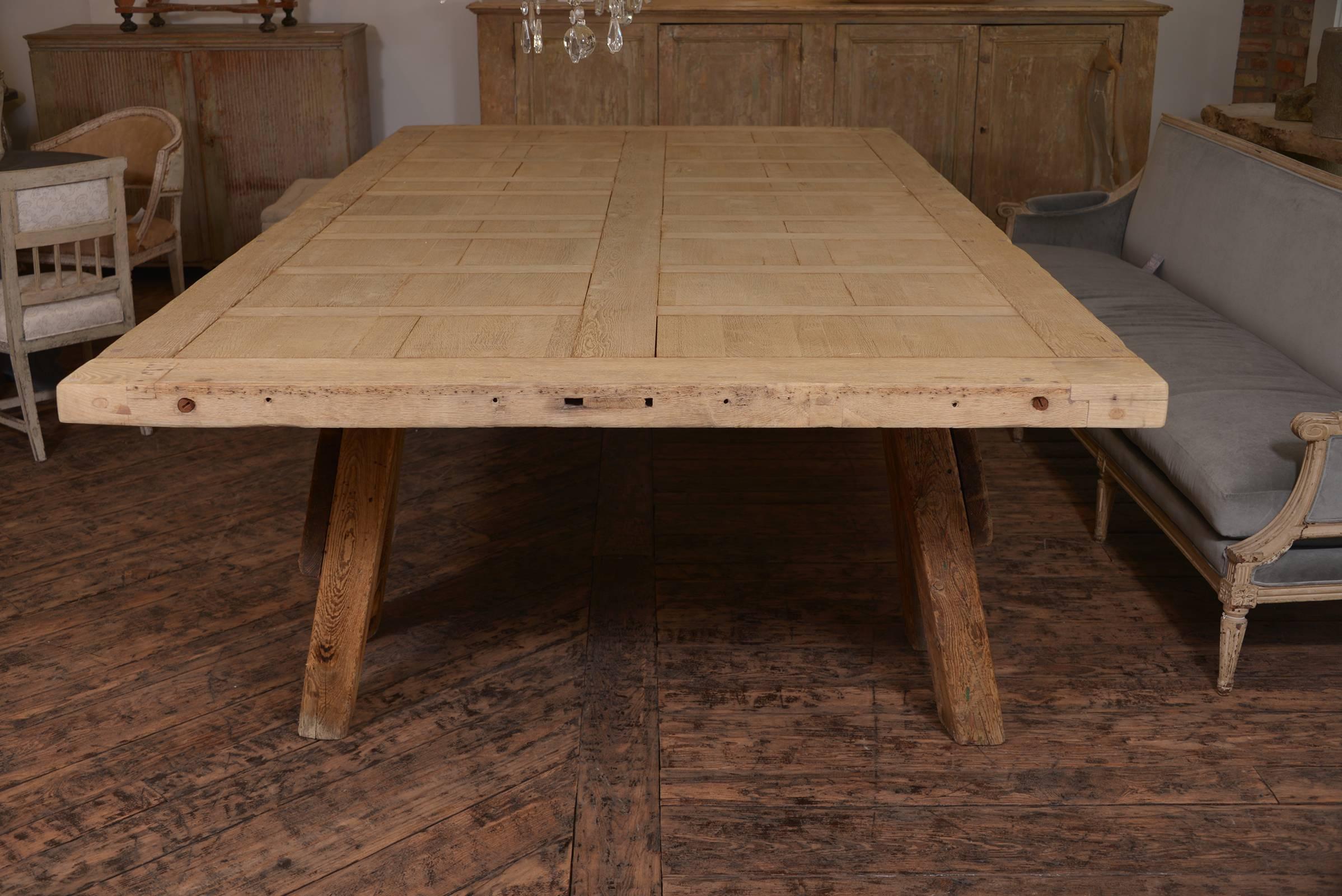 Amazing large scaled French dining table on two saw horses, wood is a French oak that has been stripped- originally the top was a door, one piece of remarkable wood. An incredible table. The top is 3 inches thick.