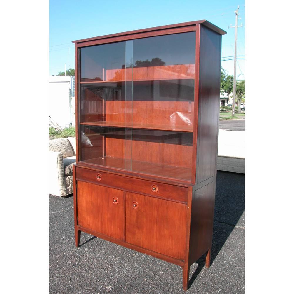 Mid-Century Modern hutch deigned by John Van Koert for Drexel’s counterpoint collection.
 
Two-piece cabinet with removable sliding glass panels for the top.
Two shelves consist of glass which rest in a wooden frame and can be adjusted to your