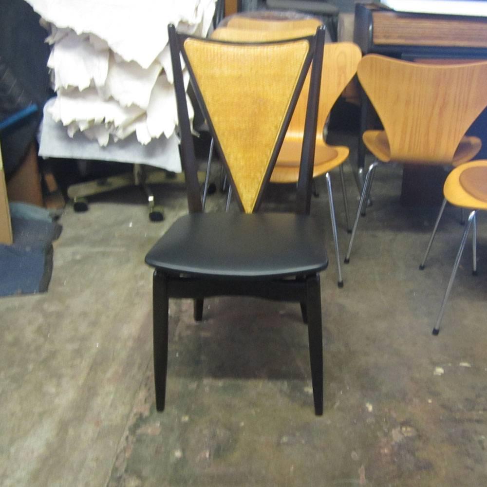 A set of six stakmore Mid-Century Modern cane back folding chairs. These chairs are constructed with a wooden frame and cane back. What makes these chairs stand out is that they are able to fold while still maintaining the classiness and sturdiness