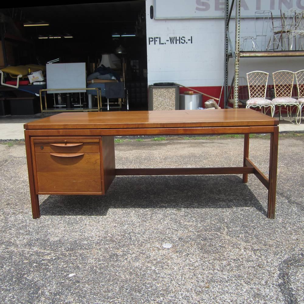 A vintage Mid-Century single-pedestal walnut desk made by Jens Risom fully restored. This desk features two drawers with a pencil drawer and a pull-out surface. This Classic piece of modern Danish design will look great in any home or office.