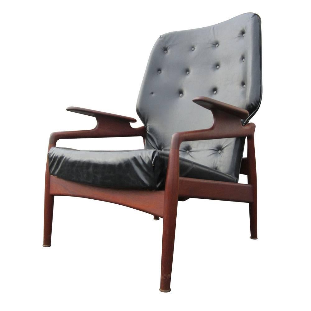 Vintage John Bone style reclining lounge chair. A Danish teak lounge chair which sits straight up or reclines at an angle. It has black leather upholstery and has a manually operated mechanism under seat.   A comfortable and stylish reclining chair