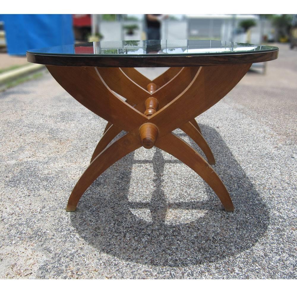 This vintage Mid-Century piece is an elegant, beautifully designed glass top dining table. A rosewood table featuring a cross leg  design with a sculptural aesthetic stem, along the cross section of the base. Measures: 87