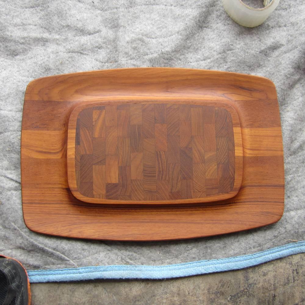 A vintage staved teak cutting or serving cheese board designed by Jens Quistgaard for Dansk. This lovely tray has a raised platform in the middle and a curved dip along the sides. This cheese tray is a wonderful example of Scandinavian modern