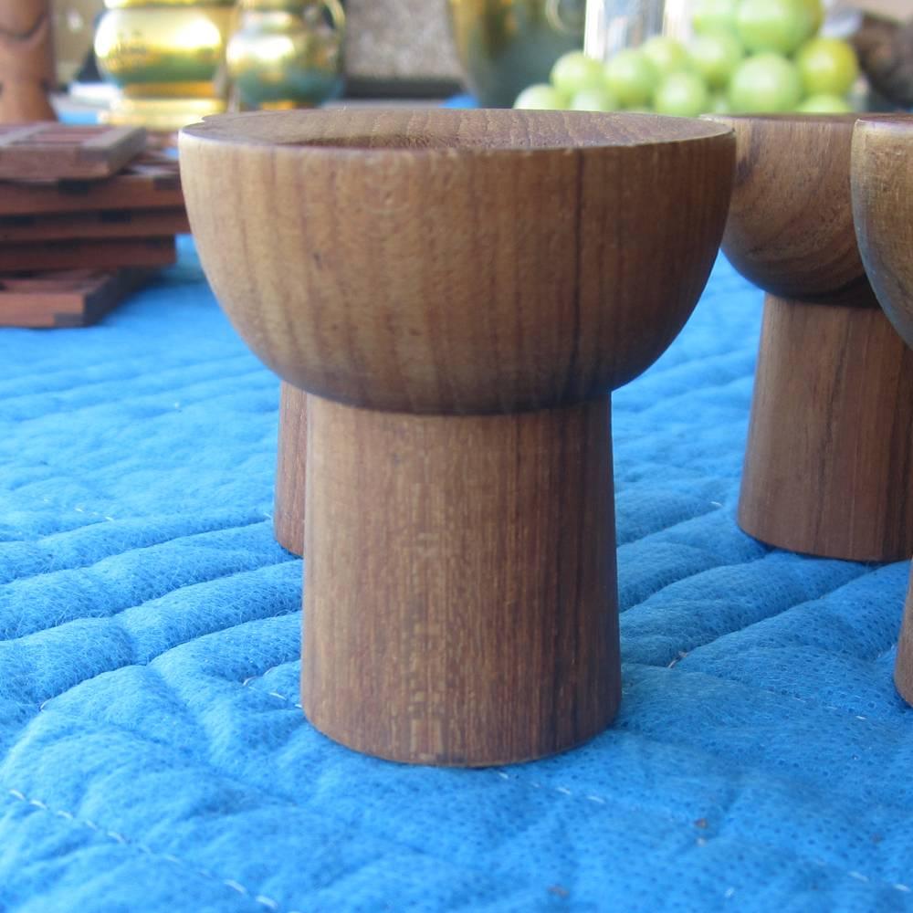 Laurids Lonborg.

A set of vintage Danish teak egg cups, toothpick holders, and a serving tray manufactured by Lonborg. There are four egg cups designed to be a unique way to present poached or hardboiled eggs. Two toothpick holders have an