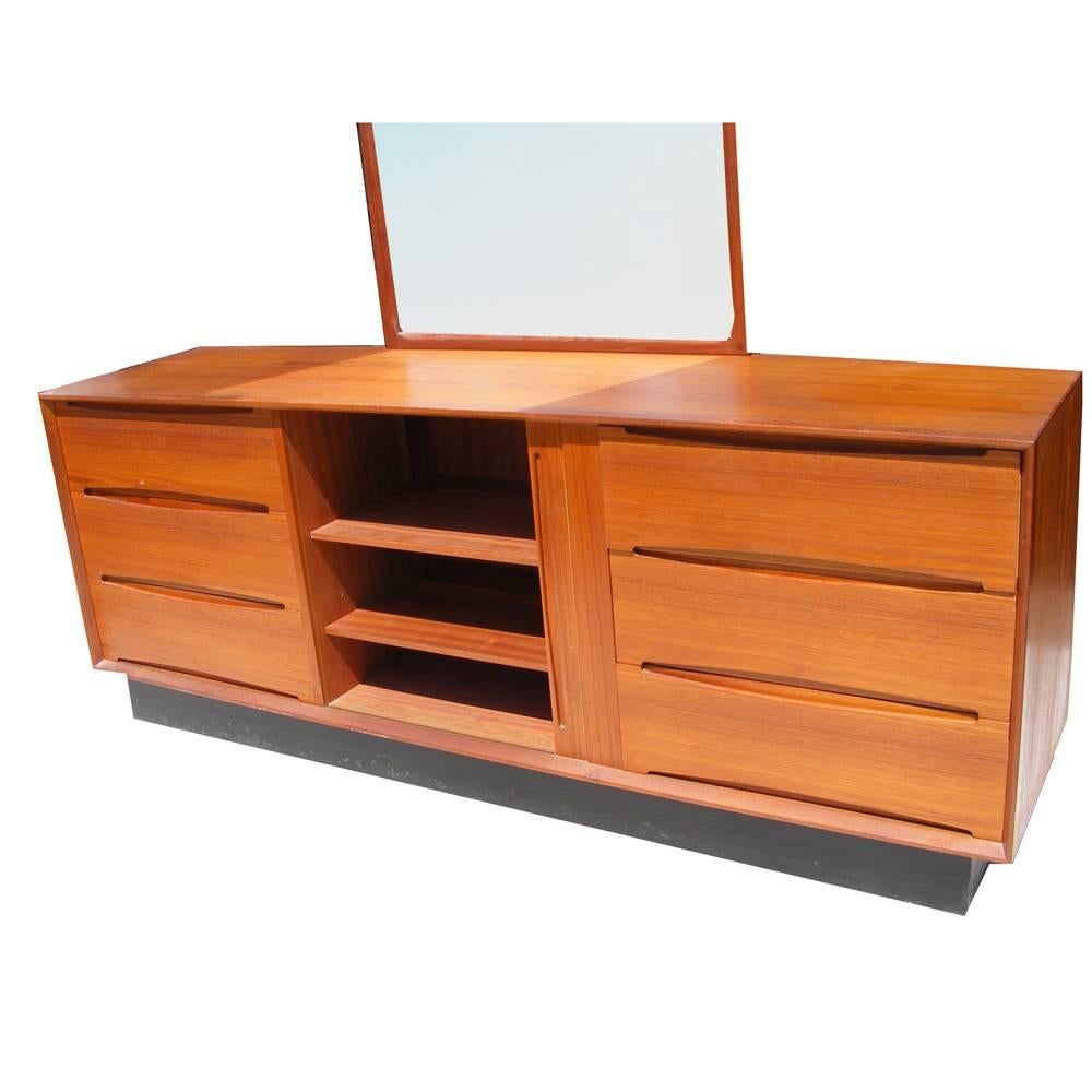 Vintage Mid-Century teak
Dyrlund dresser with mirror by Aksel Kjersgaard

Teak mounted on ebonized base. Can be used as dresser with attached mirror or buffet credenza. 

Teak with ample storage. Six drawers and sliding cabinet with two shelves.
