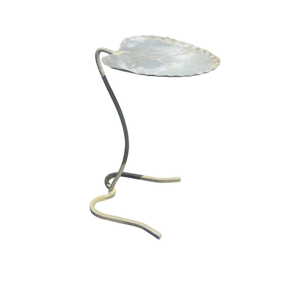 A vintagepair cast iron side tables in the shape of a large lily pad manufactured by Salterini. Also available are matching patio chairs as seen in the last picture and a wrought iron and glass table also by Salterini.