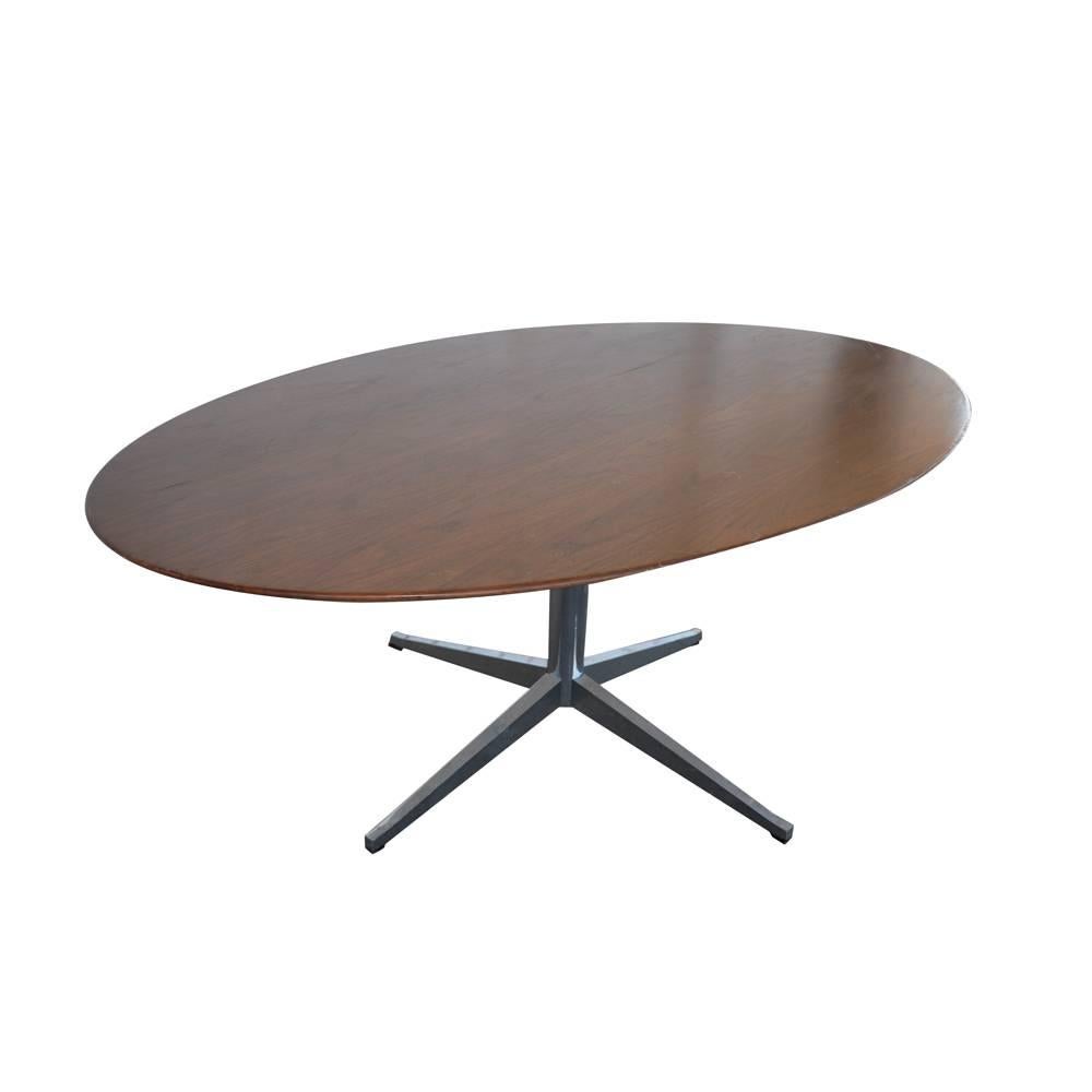 A Mid-Century Modern table designed by Florence Knoll
which could be used for dining, conference, or as a desk. An oval walnut top with a chrome four star base. Both the frame and legs are heavy gauge steel. The post and four star legs are chrome