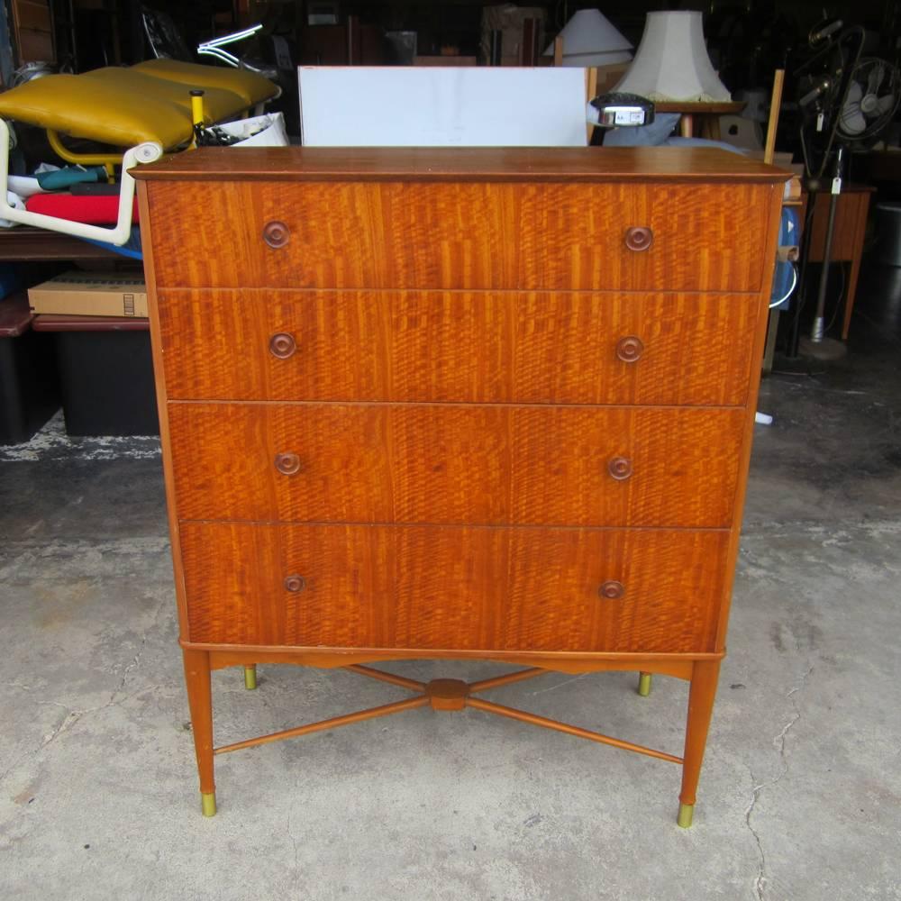 A well-finished Mid-Century Modern cabinet with eight hand-carved wooden drawer pulls and cross-support for the legs. Four spacious drawers allow for excellent space utilization. Perfect for any home or bedroom.