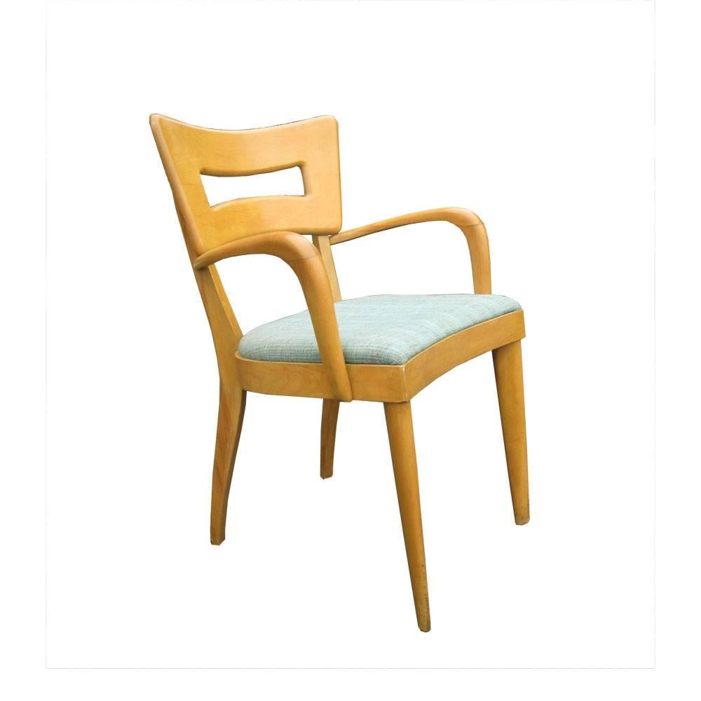 A set of eight vintage Heywood Wakefield Dogbone chairs with a green fabric seat. Note that two of these are armchairs while the rest are side chairs. This iconic chair is one of Heywood Wakefields most iconic designs and has come to represent the