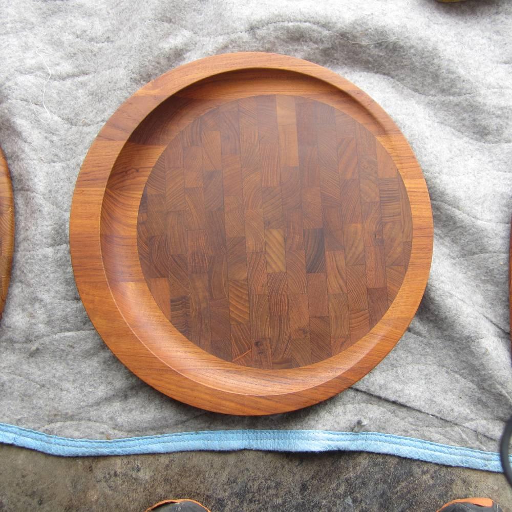 A vintage Mid Century teak and walnut inlay round cutting, chopping, serving board dating designed by Danish design great Jens Quistgaard during the late 1950s. 
Graceful and functional with a raised and slanted design. An exceptional example of