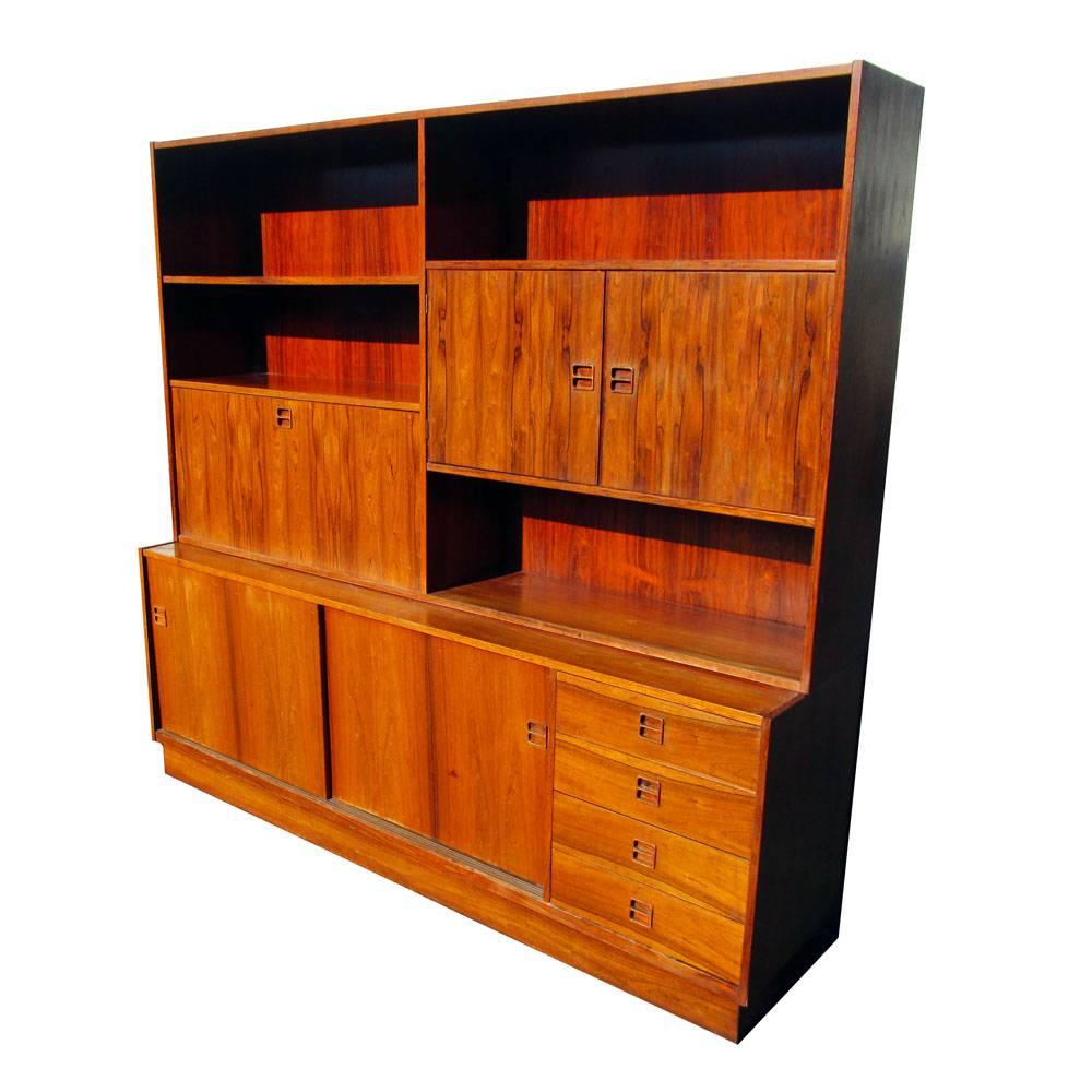 Vintage mid century rosewood bookcase / wall unit by Poul Hundevad for Aerthoj Jensen and Molholm Herning 
Top unit has four green felt-lined covered by a drop desk, open shelves; there are six smaller shelves inside two doors storage area. Bottom