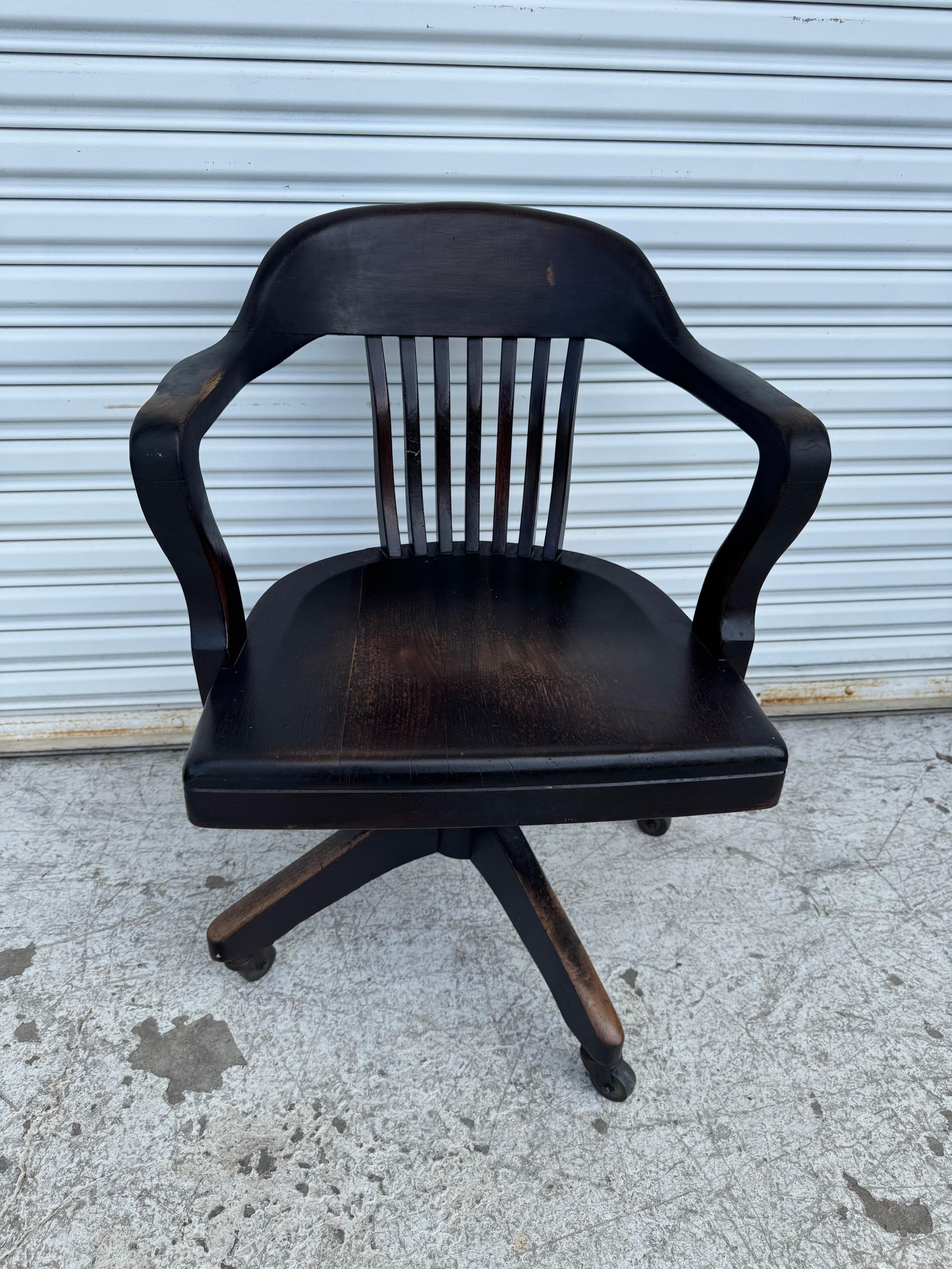 Chaise de bureau pour avocats de bibliothèque en noyer américain ancien du début du 20e siècle, vers les années 1930. Il est doté d'un dossier incurvé, d'un siège profilé, d'un mécanisme de pivotement et d'inclinaison et de roulettes pour faciliter