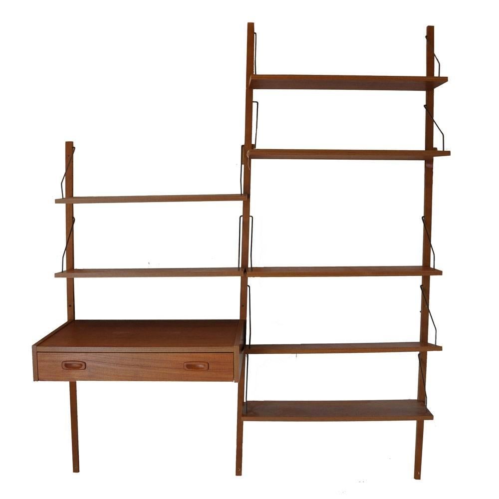 Cado

Poul Cadovius.

Vintage Danish wall unit in style of Poul Cadovius for Cado. 
Simple and elegant with adjustable six shelves and a drawer floating desk.

Measures: 78.5