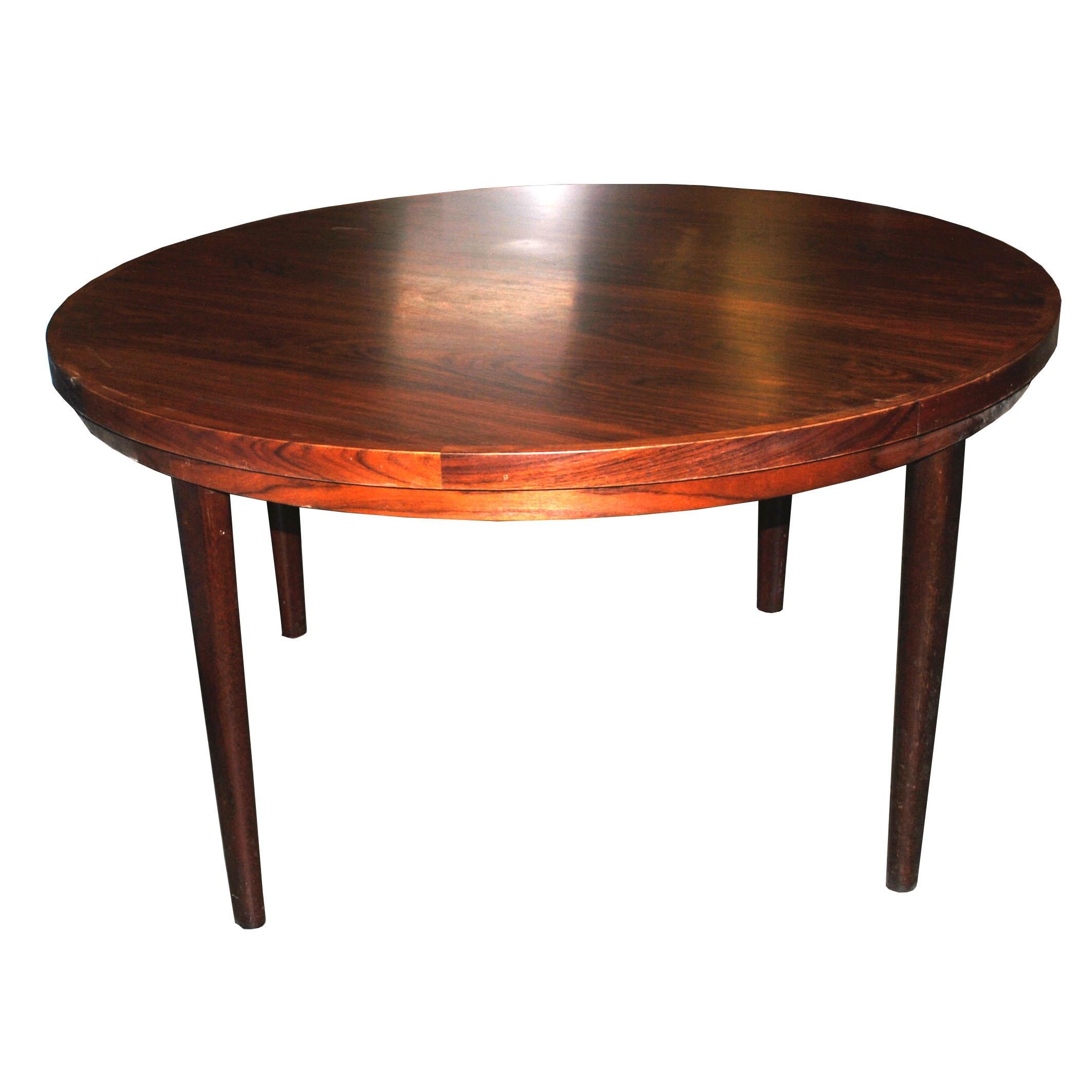 A vintage Danish dining table made of beautiful rosewood. This table has a unique rotating tabletop.   Stamped made in Denmark.