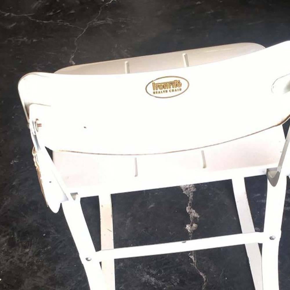 Un'insolita sedia sanitaria Ironrite disegnata da Herman A. Sperlich in un bel colore bianco.  telaio e seduta in acciaio smaltato.  