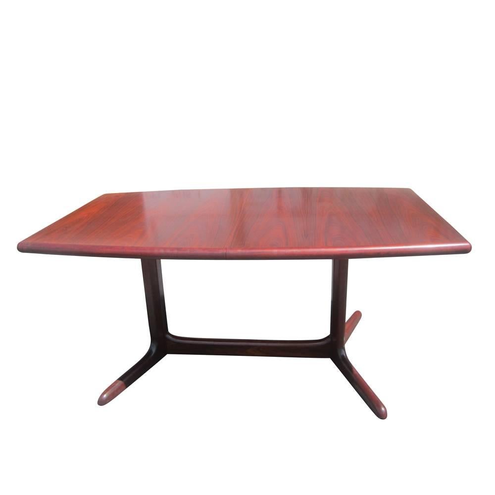 A vintage rosewood conference or dining table manufactured by Dyrlund. Dyrlund prides itself on creating wooden furniture that enhances the natural quality of the wood itself, and this stunning table is no exception. The table features two leaves