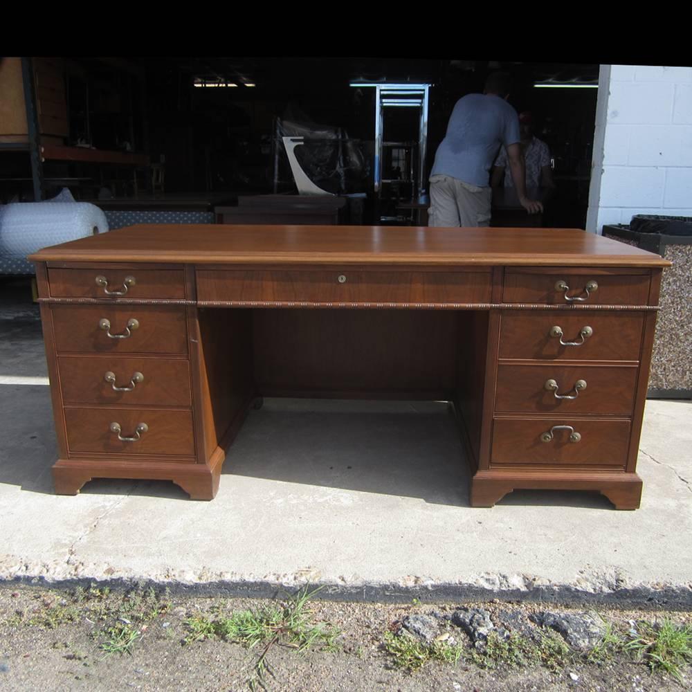Shelbyville Desk Co.
 
A vintage double pedestal Shelbyville desk with a walnut finish. This desk features a pencil drawer in the center and eight additional drawers on the pedestals in addition to two extending writing surfaces on the front and