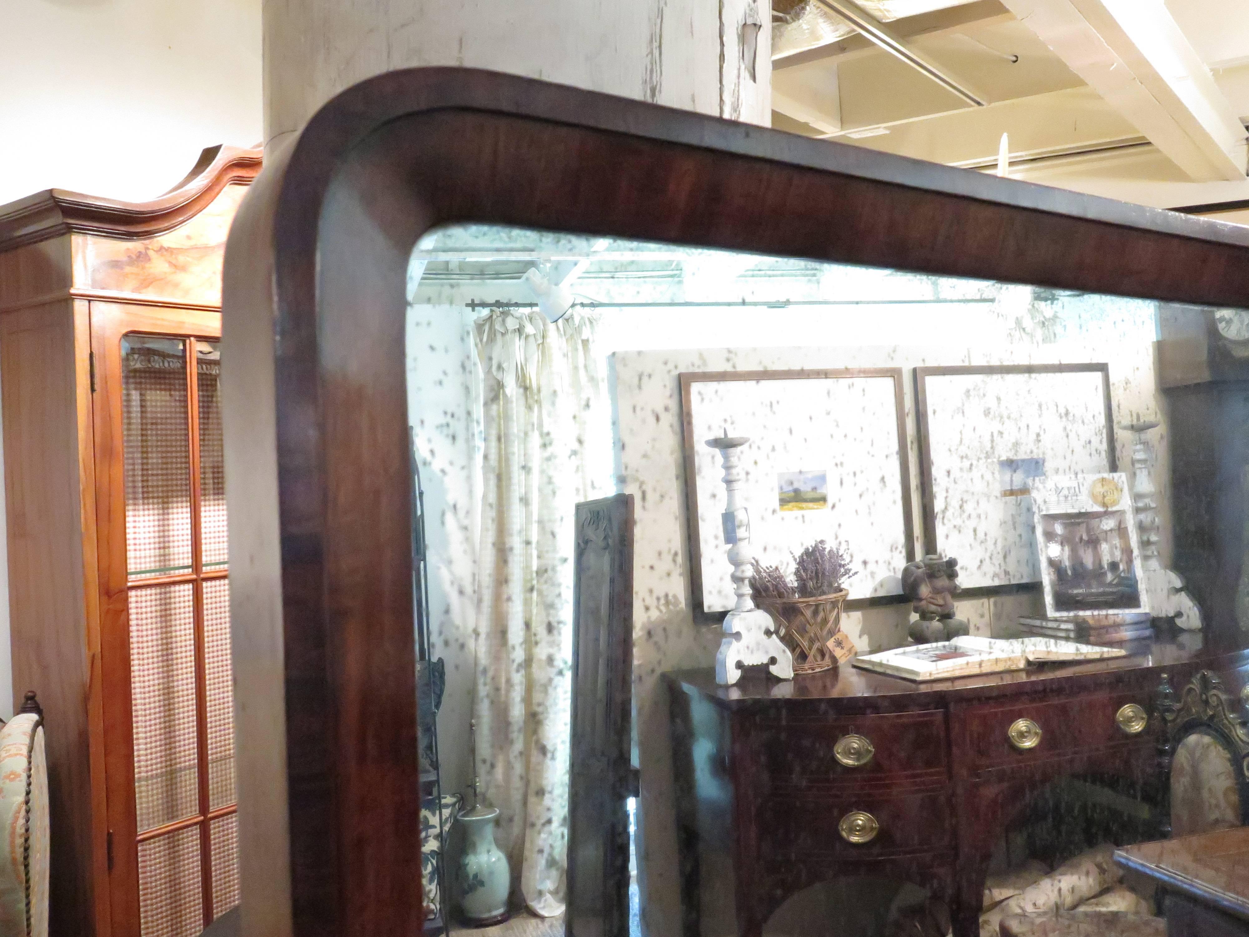 French mahogany cheval mirror flanked by urn finials on an adjustable frame. Mirror stands on four original brass casters. Mirror alone is 45.75
