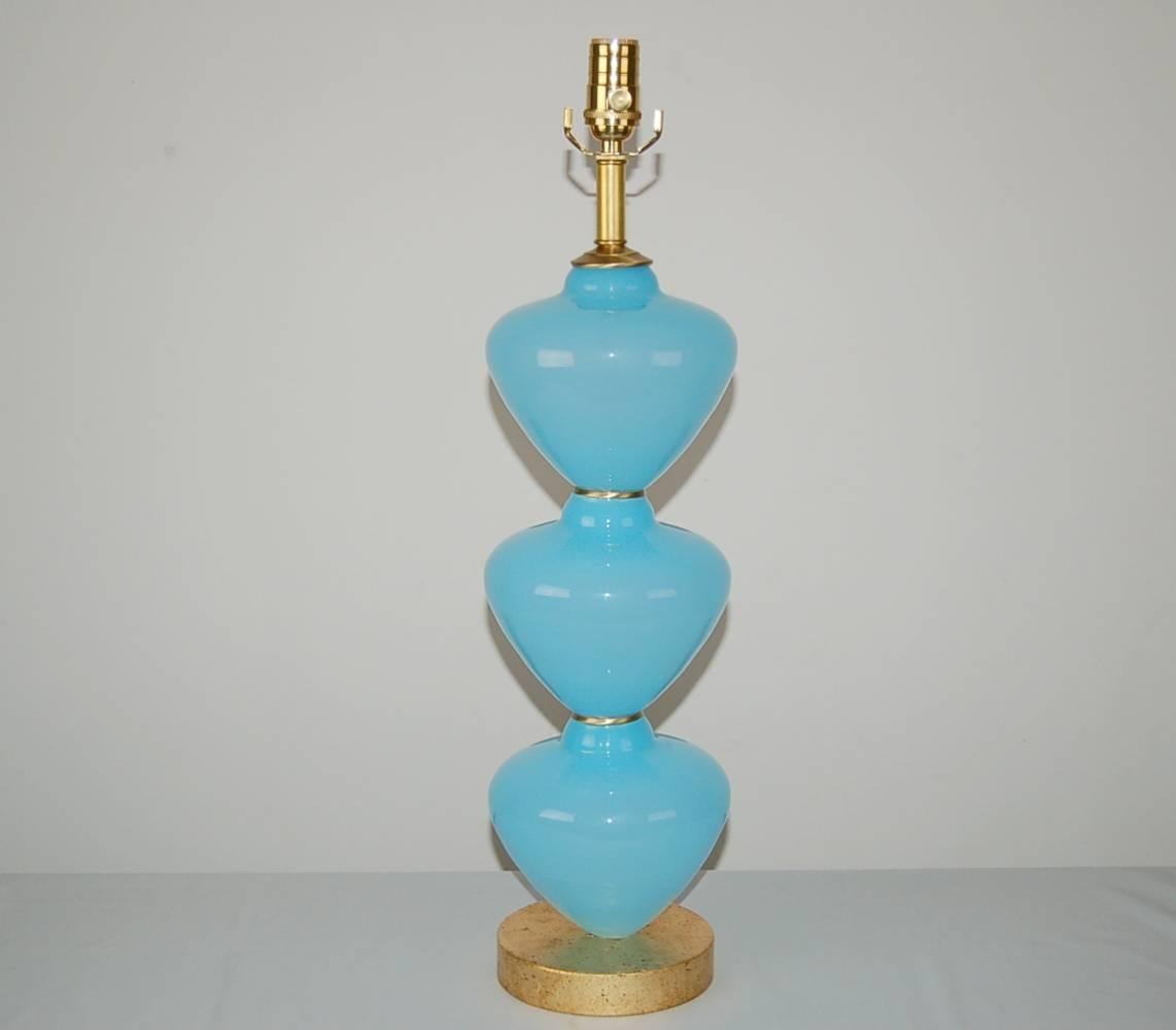 Matched pair of vintage Murano table lamps. Stunning stacked fonts in eye-catching SKY BLUE, with brass accents between and atop, and gold leafed bases beneath. 

They stand 25 inches from tabletop to socket top. As shown, the top of shade is 30