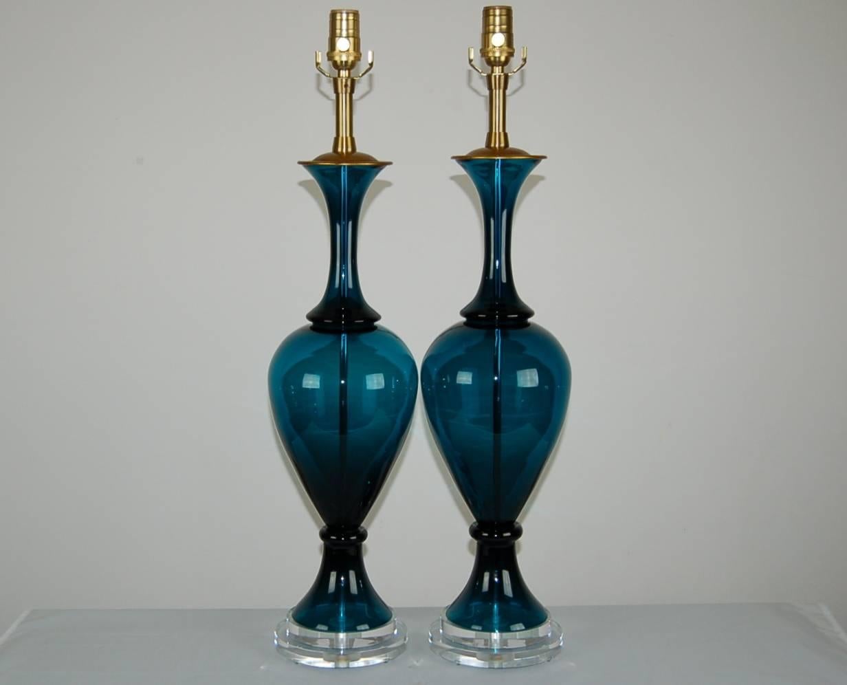 A matched pair of vintage Murano handblown glass lamps in Teal by The Marbro Lamp Company. The three-piece glass is semi translucent, the color and curves give these lamps a dramatic, moody look. 

They measure 28 inches from tabletop to socket