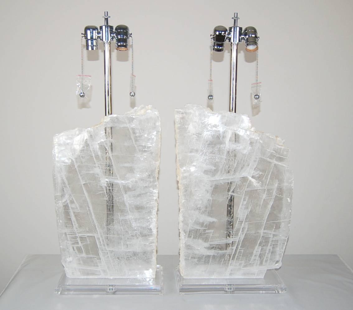 Thick slices of polished Selenite that look like million year old slabs of ice from a glacial crevasse. The slices are 12 inches at their widest and 18 inches tall. 

They stand 27 inches from tabletop to socket top. As shown the top of shade is