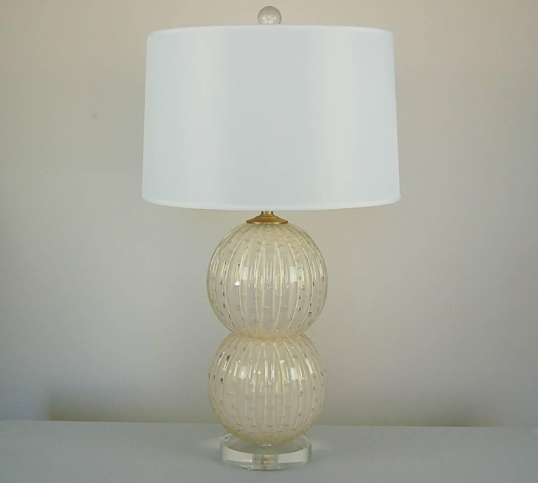 Elegant Murano glass stacked ball lamps, circa 1994. The white balls are filled with controlled bubbles, sprinkled lightly with gold dust. 

They stand 21 inches from tabletop to socket top. As shown, the top of shade is 27 inches high. Lampshades