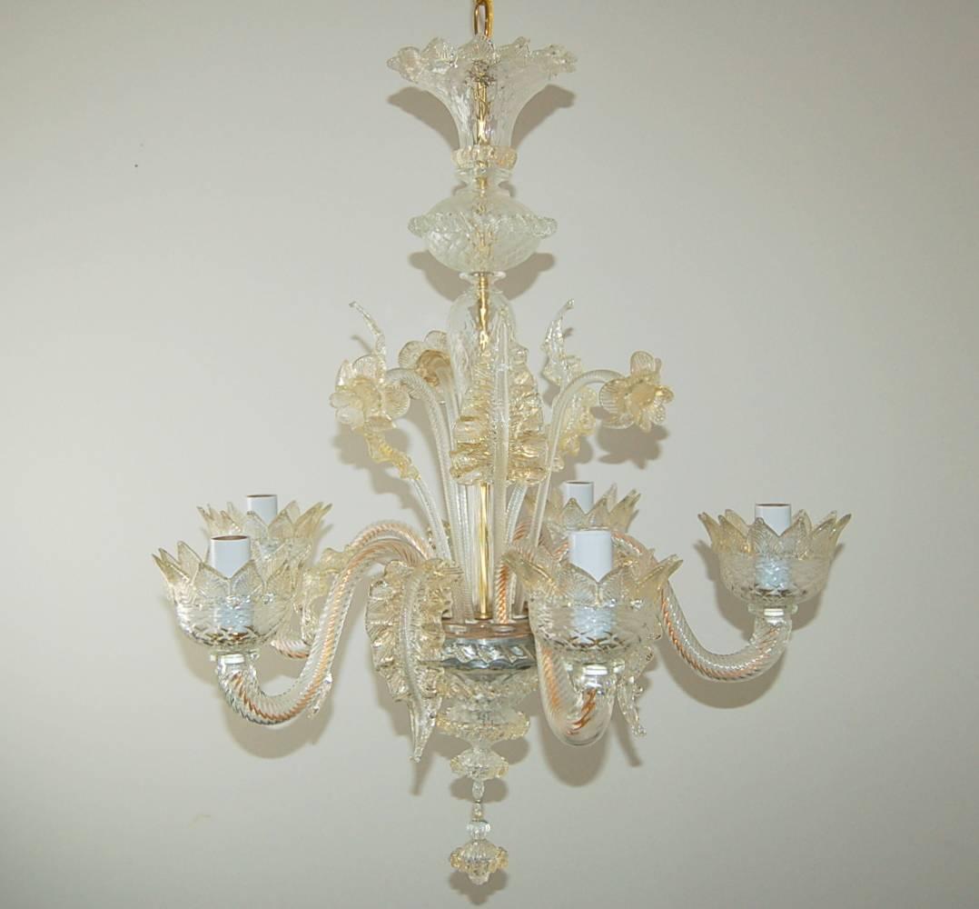 Very chic vintage five-light Murano glass chandelier, circa 1950s, made of Murano clear crystal glass filled with gold dust. Newly rewired and rebuilt. 

The chandelier is 22 inches in width and 30 inches in height, from glass to glass. Completed