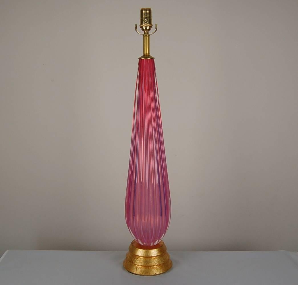Towering vintage Murano lamp of PINK/ORCHID OPALINE by Archimede Seguso. The color is quite intense and has a magical aura, courtesy of the opaline. Mounted on gold leafed base.

The lamp stands 31 inches from tabletop to socket top. As shown, the