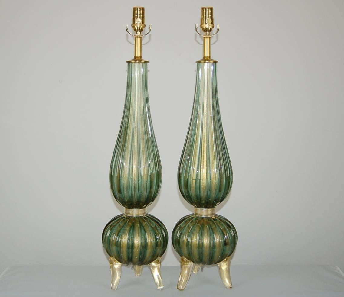 A perfectly matched pair of classic Murano three footed table lamps. The SAGE GREEN color is filled with GOLD dust.

They measure 31 inches from tabletop to socket top. As shown, the top of shade is 37 inches high. Lampshades are for display only