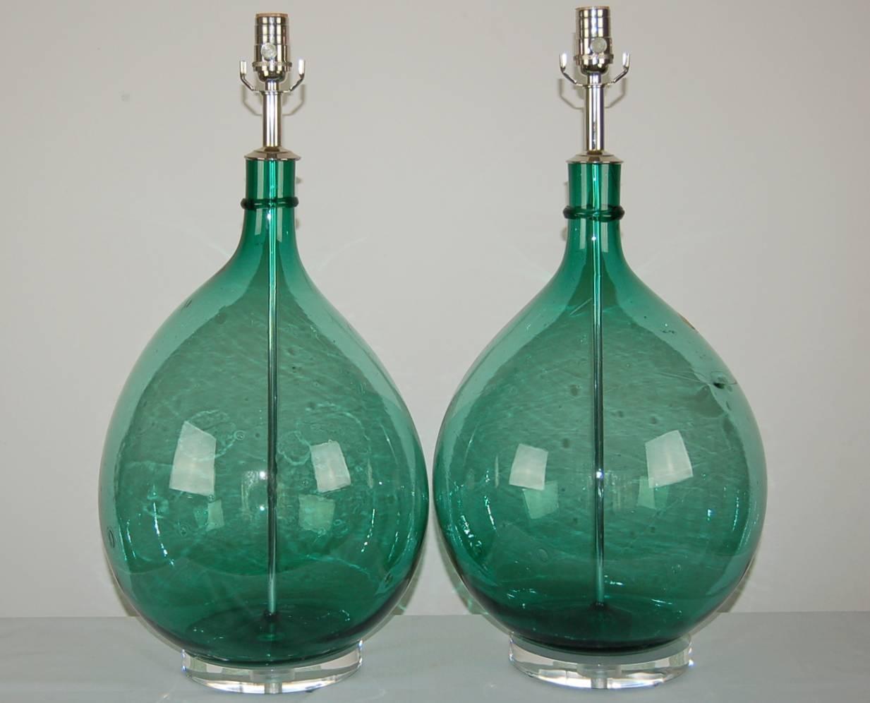 Matched pair of Vintage Murano Jugs table lamps of JADE GREEN, circa 1950s with a single ring of applied glass surrounding the necks. Substantial lamps in a very special color.

They stand 25 inches from tabletop to socket top. As shown, the top of