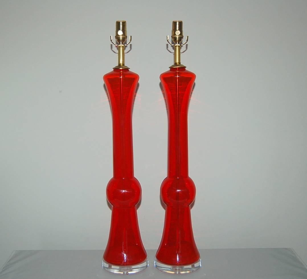 Towering matched pair of vintage Murano table lamps in transparent CHERRY RED. Sculpted and sleek!

They stand 31 inches from tabletop to socket top. As shown the top of shade is 36 inches high. Lampshades are for display only and not available for