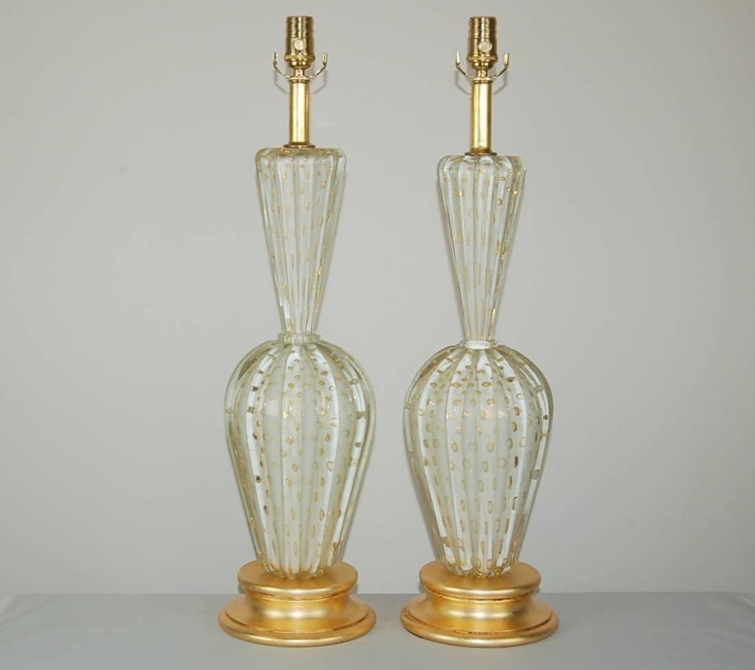 Matched pair of vintage Murano glass table lamps filled with large controlled bubbles rimmed in GOLD.The SNOW WHITE glass is in perfect condition. If you are wanting the best lamps the era had to offer, these are they. Mounted on gold leafed bases