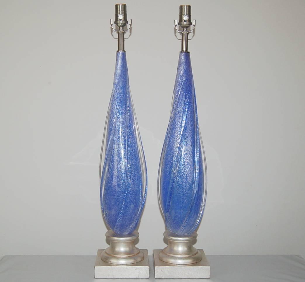 Matched pair of vintage Murano Pulegoso table lamps in COBALT BLUE with pedestal bases made of silver leaf. The large, sexy lamps are filled with thousands of bubbles, mounted on of bases in silver leaf. Clear wings of applied glass show special