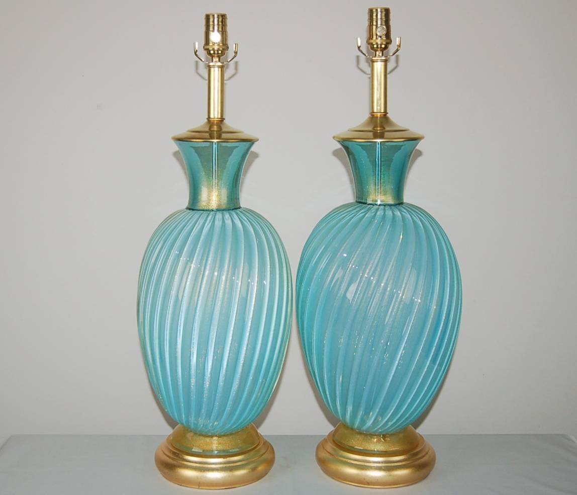 Massive signature pair of SKY BLUE vintage Murano Italian table lamps by Archimede Seguso. Hollywood Regency elegance on gold leafed bases and brilliant gold dust throughout. 

The lamps measure 28 inches from tabletop to socket top. As shown, the