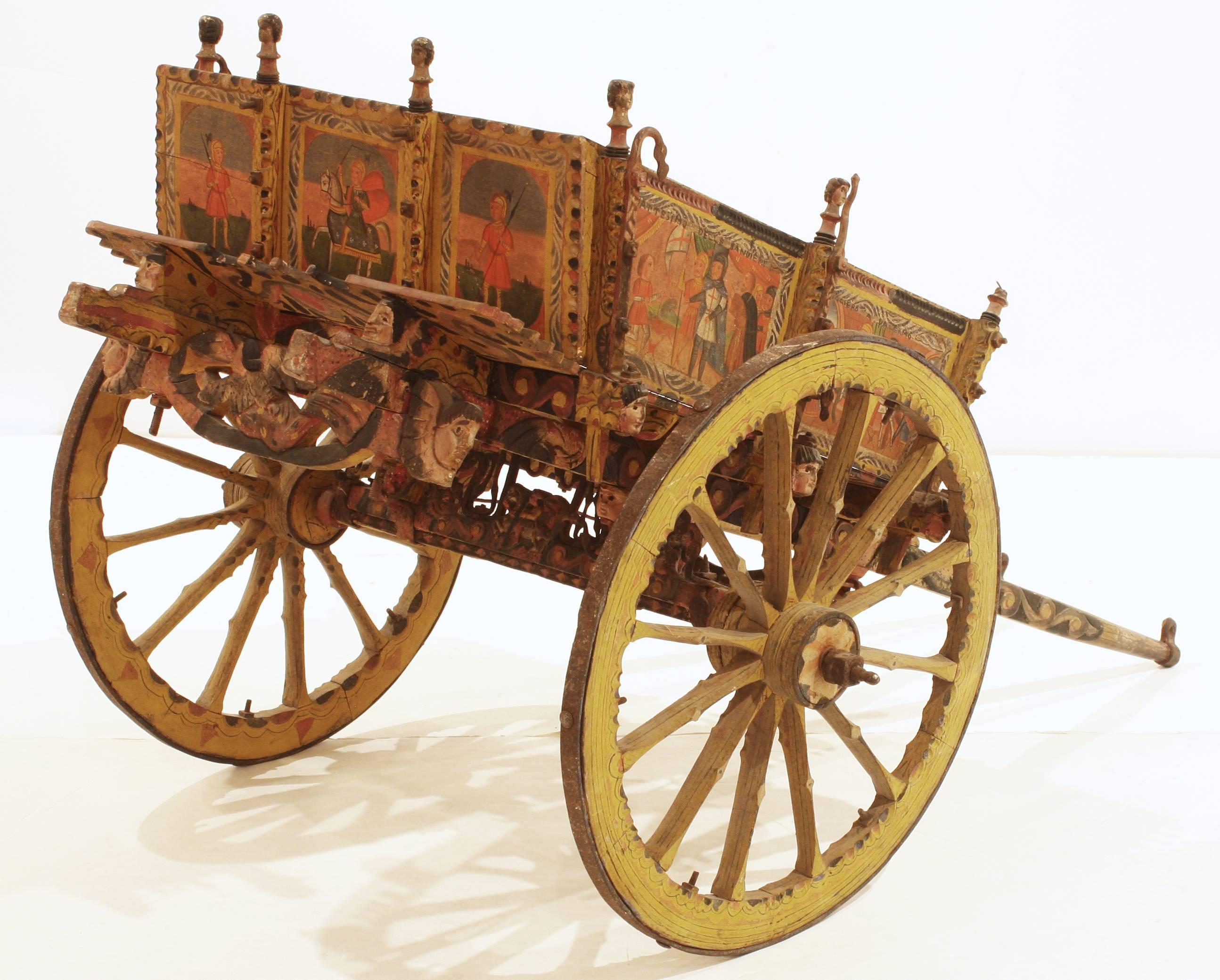 Multi-color painted and carved wooden child-size Sicilian wedding or festival cart with original paint and hand-forged iron axle.