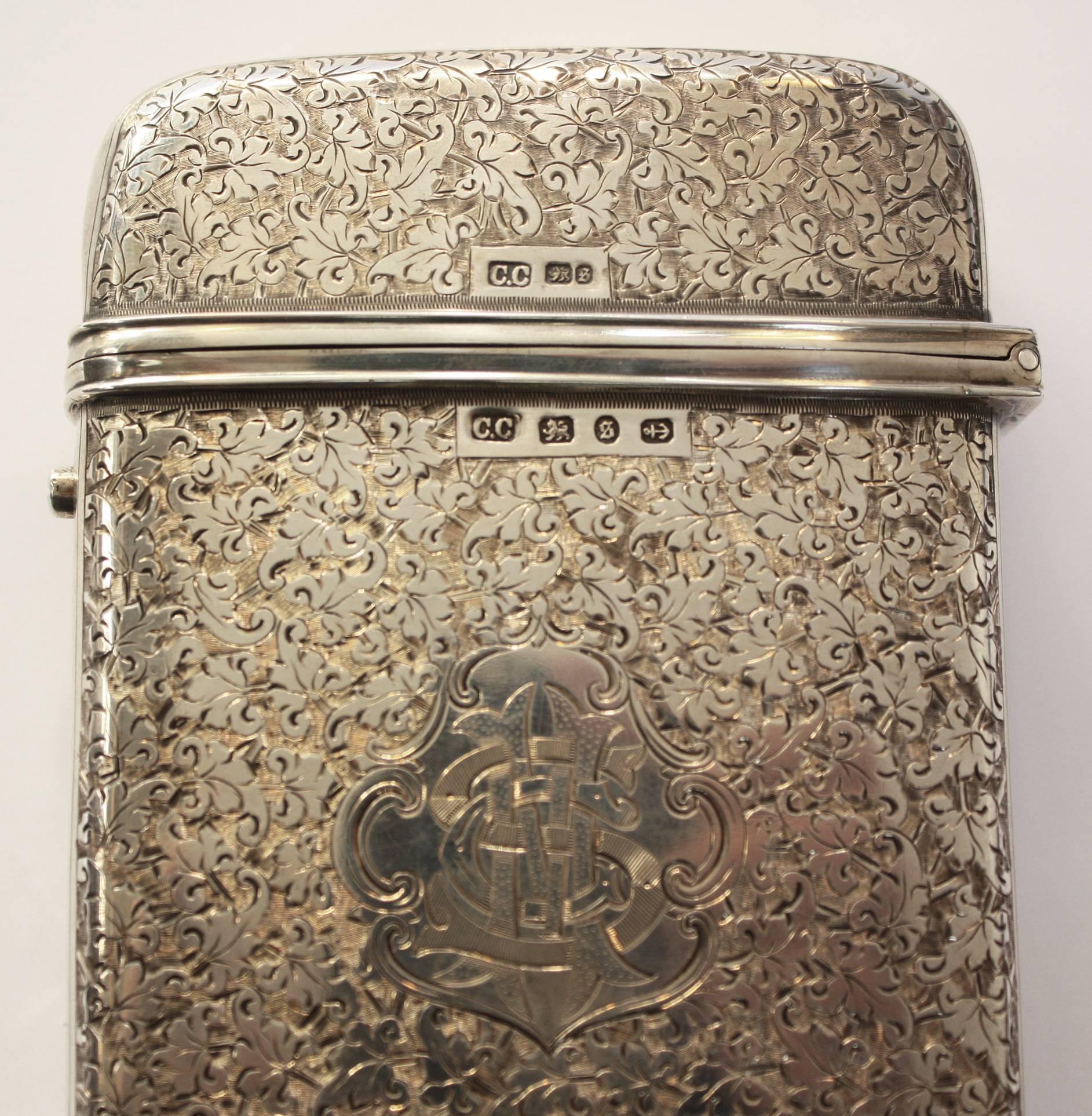 A rare, large and heavy sterling silver English cigar case with overall floral design and chained bellflower motif along the sides.

Monogramed on top and marked with hallmarks for Birmingham, England, 1892, by silversmiths Colen Hewer Cheshire.