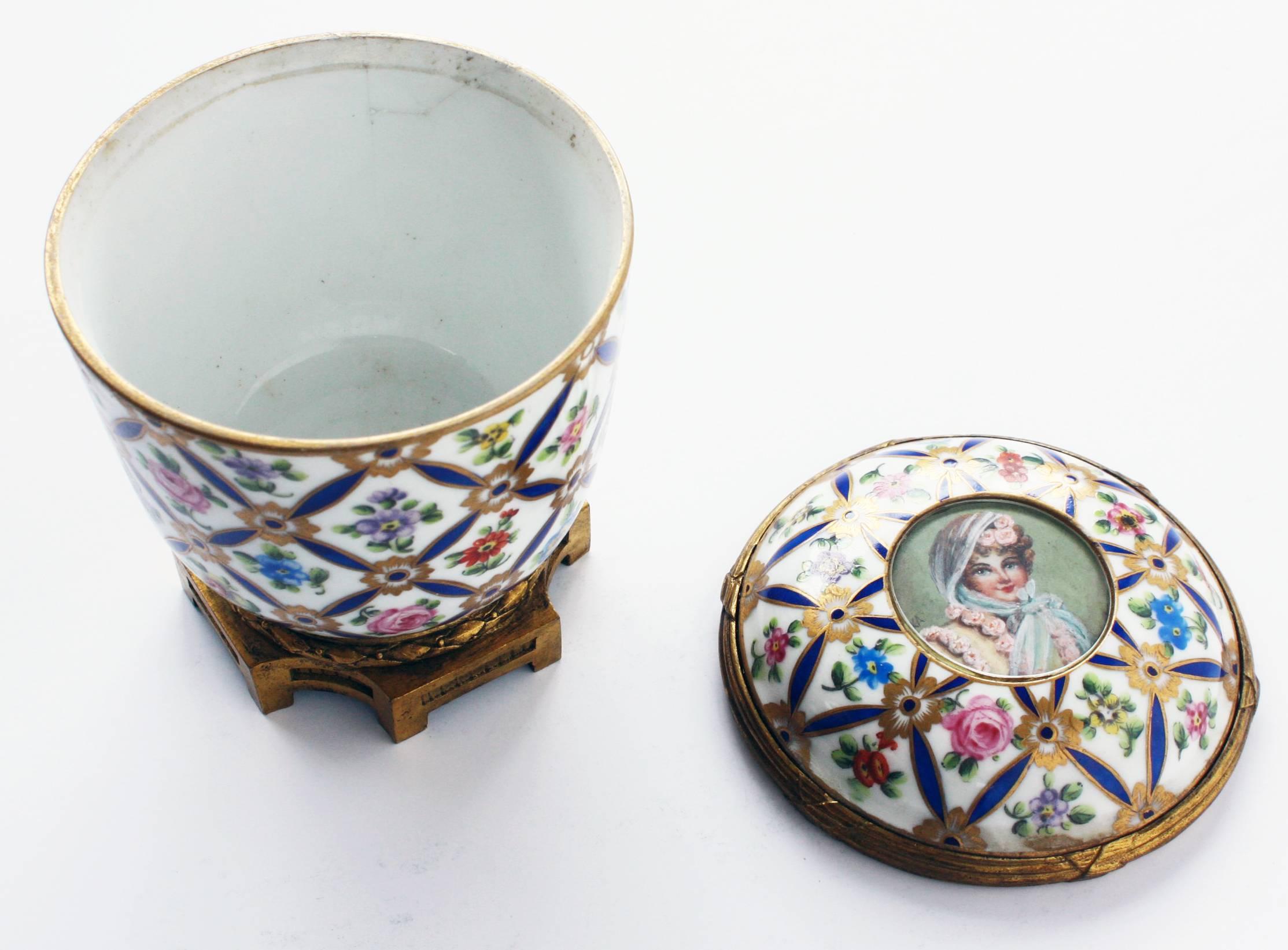 a porcelain covered jar with overall floral enamel-like pattern and gold accents. On the lid is a portrait signed 