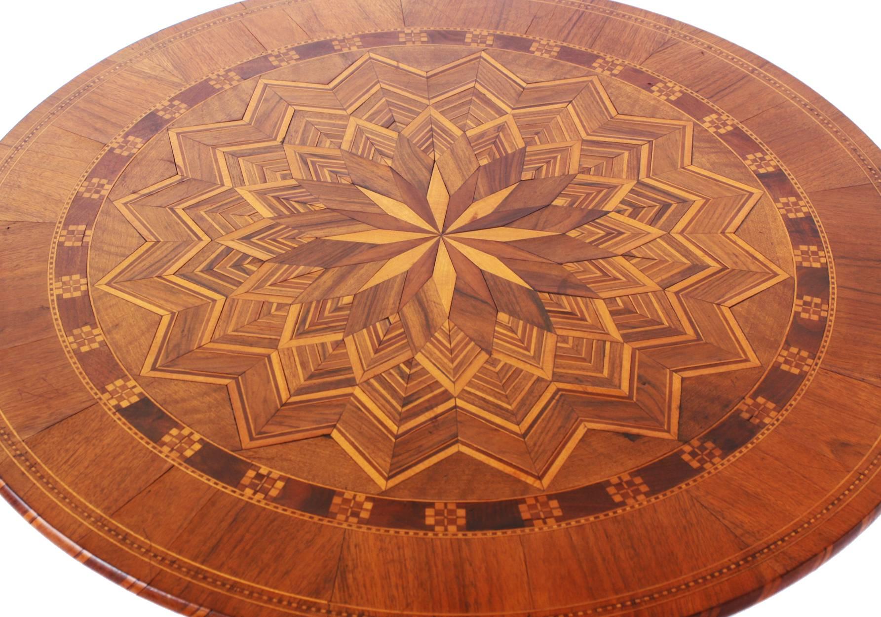 19th century Italian occasional table with an elaborate multispecies inlaid starburst pattern top which sets on a pedestal base with tripod feet.

Made in Italy label affixed. (See image 3).