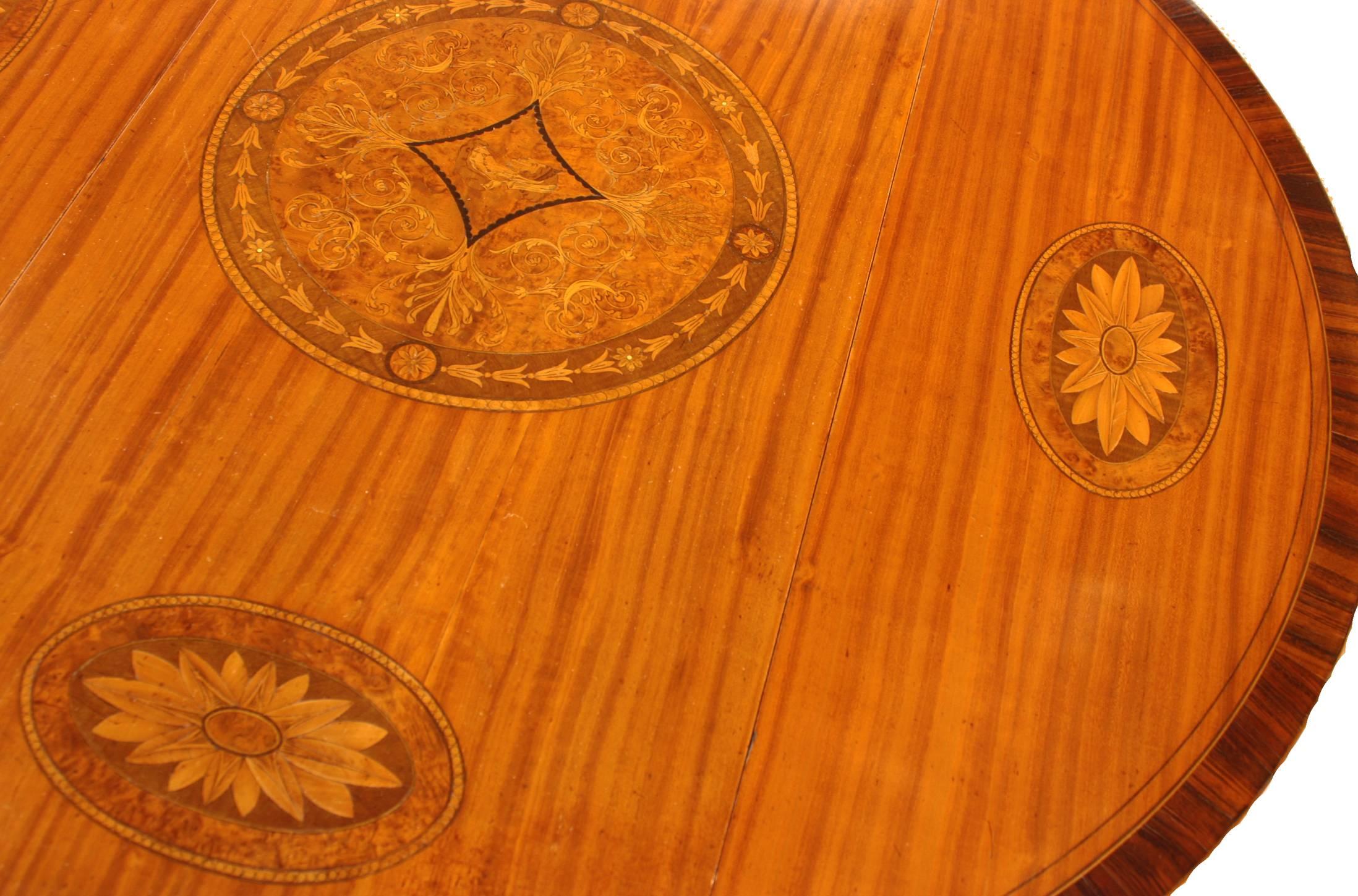A Georgian Revival George III style Pembroke table of satinwood with rosewood crossbanded border, Features a center cartouche of Grecian woman's side portrait, outlined by thick ebony stringing in a diamond shape within a large round medallion of