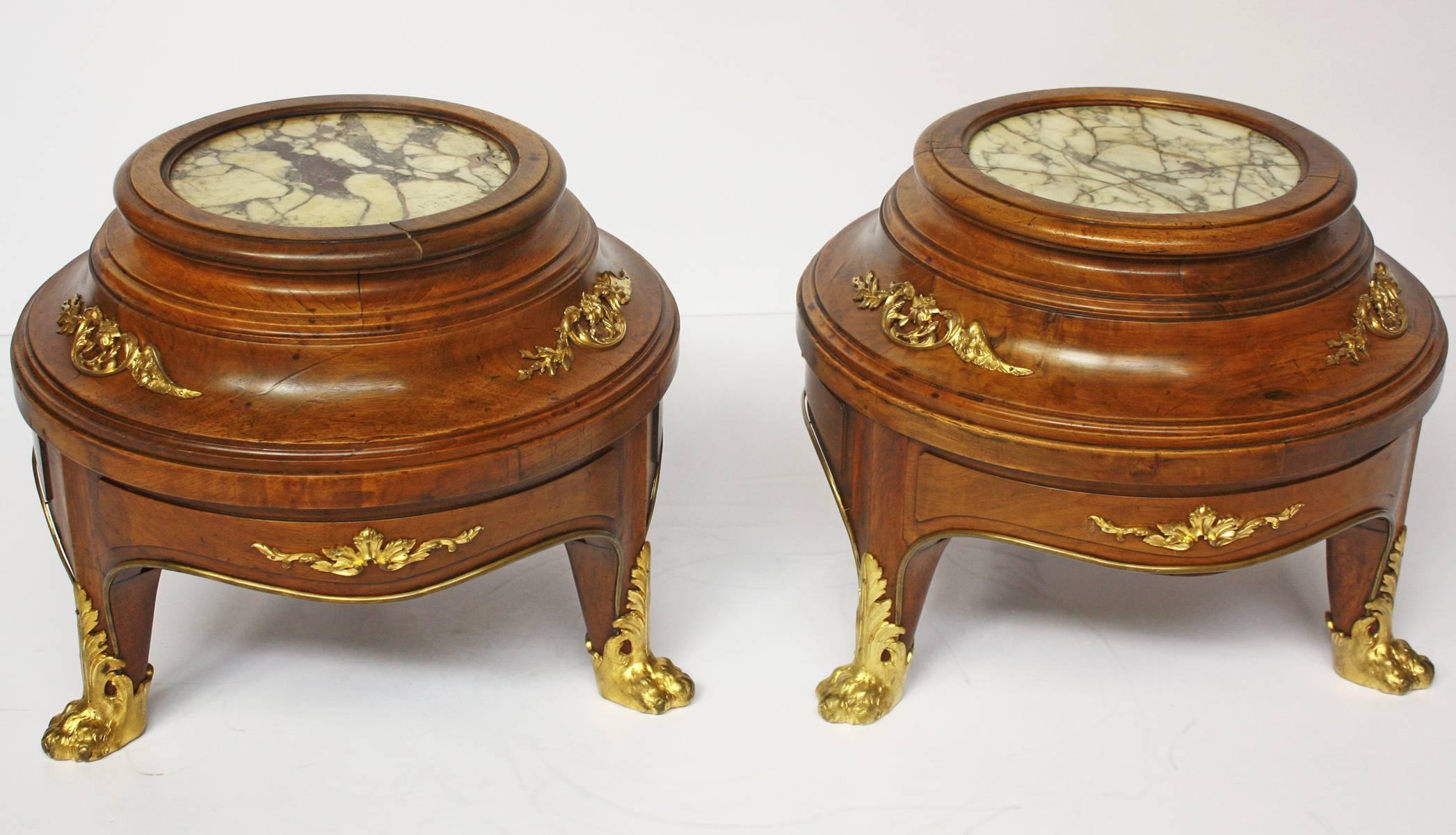 A pair of Louis XV style jardiniere or fish bowl stands of walnut with ormolu or gilt bronze mounts and marble insets on four down swept legs with hairy paw sabots, France, second half of the 19th century.

Marble is 9