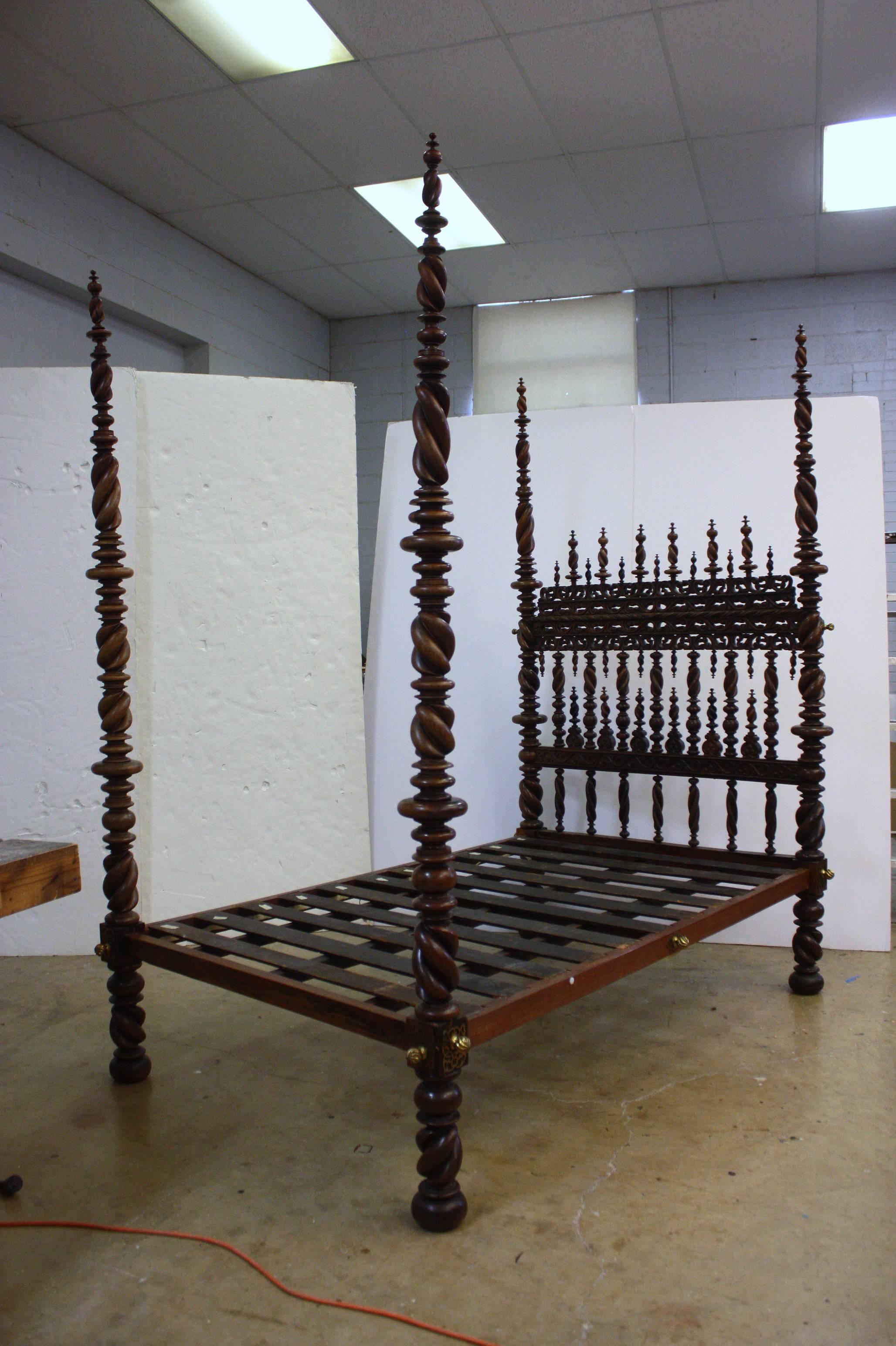 A Portuguese bed of carved and turned rosewood with 17th century elements, the headboard profusely mounted with spiral-twist spindles and the footboard between two boldly turned posts that include spiral-twists, brass bed bolts with turned detail