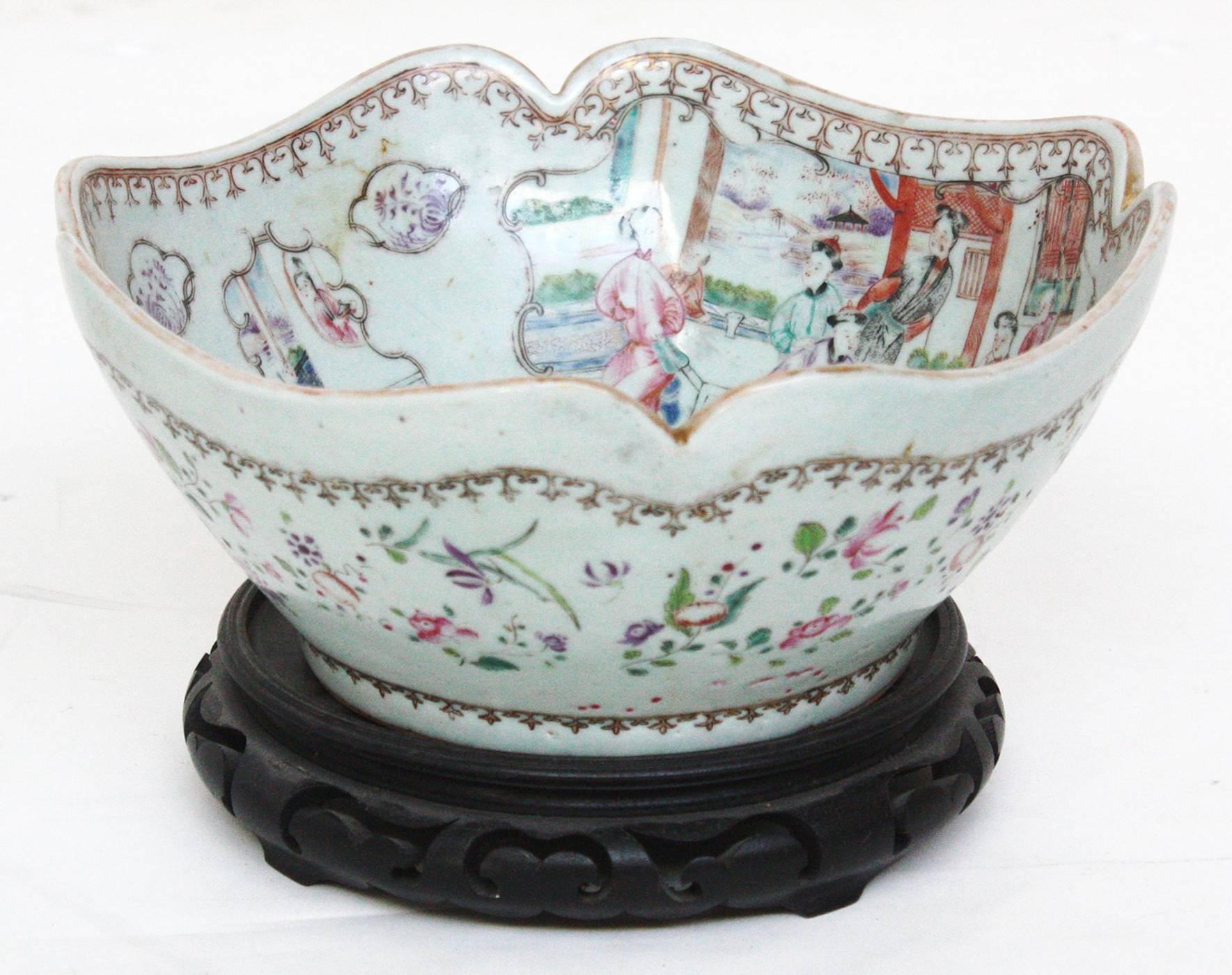 An early 19th century Chinese export porcelain bowl with a beautiful scalloped rim. Two large and two small interior panels depicting family scenes with children. Famillle rose coloration with a gilt spearhead border on inside rim of the bowl. On