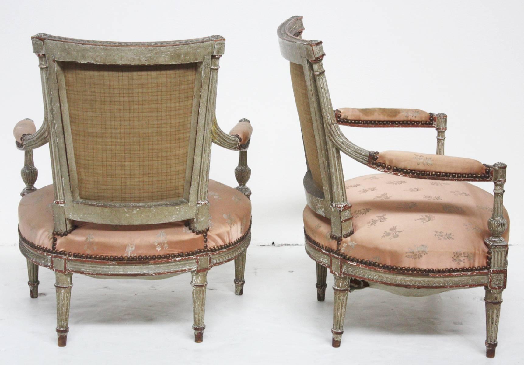 A pair of Louis XVI child's fauteuils, paint and parcel-gilt frames, pale peach silk Chinoiserie upholstery fabric decorated with sprigs of flowers, potted trees, sailing ships and small Chinese towers, the chair's seats are sprung and the seats