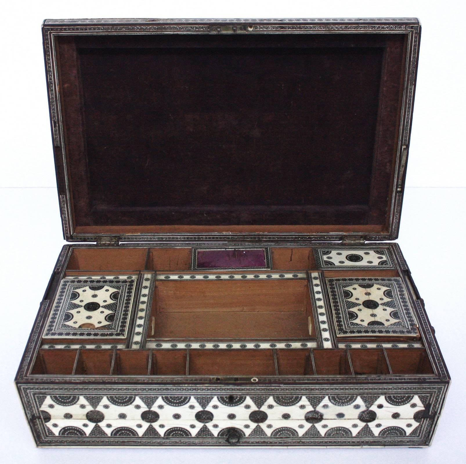 A large 19th century work box of bone and mother-of-pearl, micro mosaic decoration, interior trimmed in purple velvet with divided compartments, many with tops, some losses.