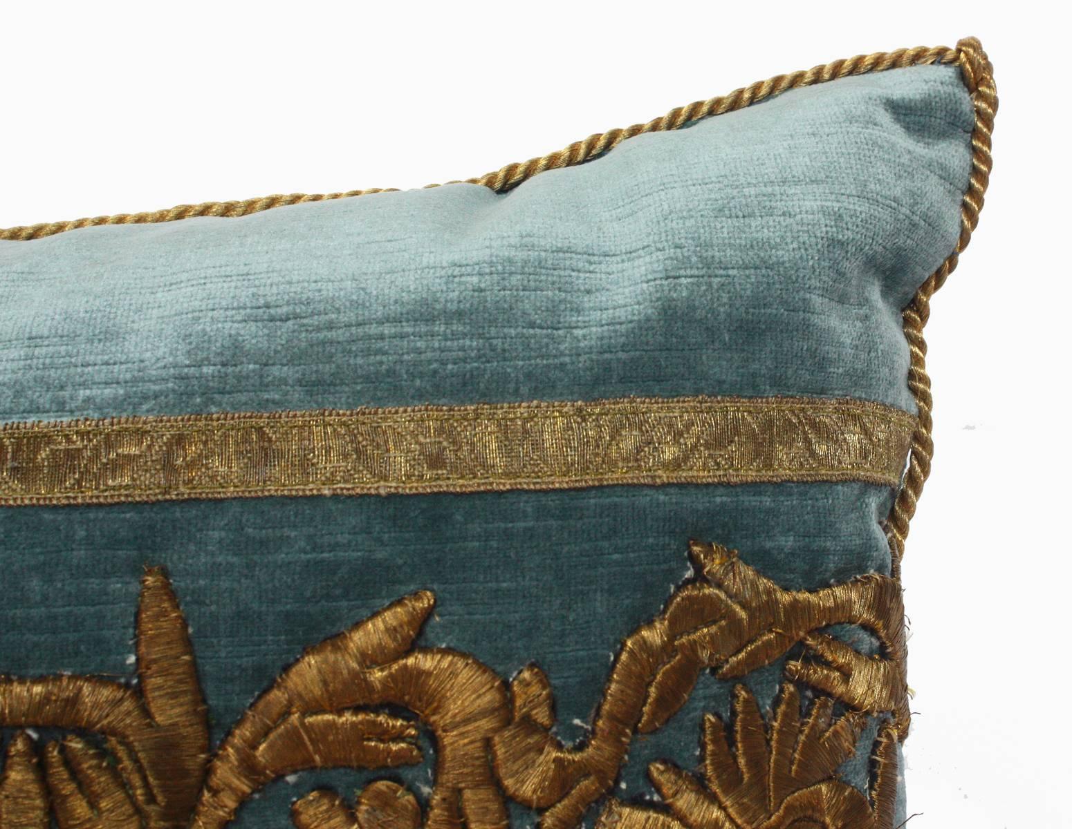 Antique raised gold metallic embroidery thought to be Egyptian or Syrian bordered with antique European gold metallic galloon on Wedgwood Blue velvet. Hand trimmed with gold metallic cording knotted in the corners. Down filled.

by Southern pillow
