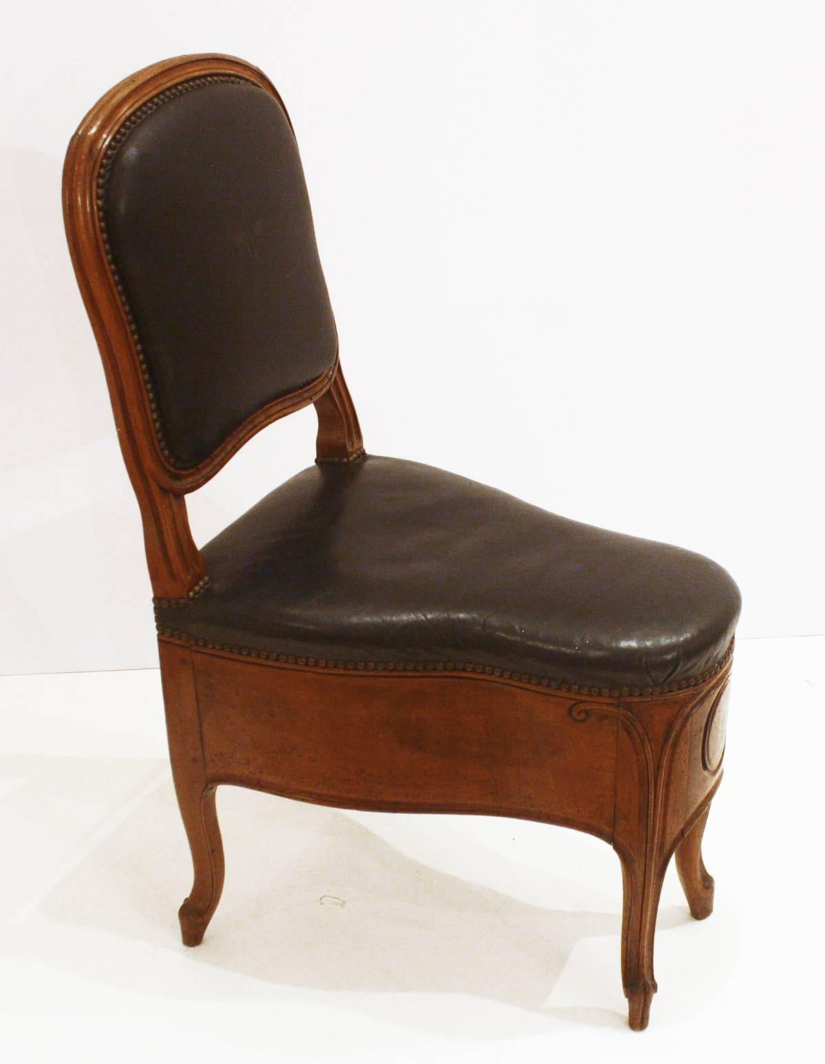 un beau bidet / chaise en bois fruitier français Louis XV sculpté, maintenant fixé dans une position fermée avec un siège et un dossier en cuir noir rembourré, garniture de tête de clou, signé / estampillé par   fabricant, France, milieu du 18e