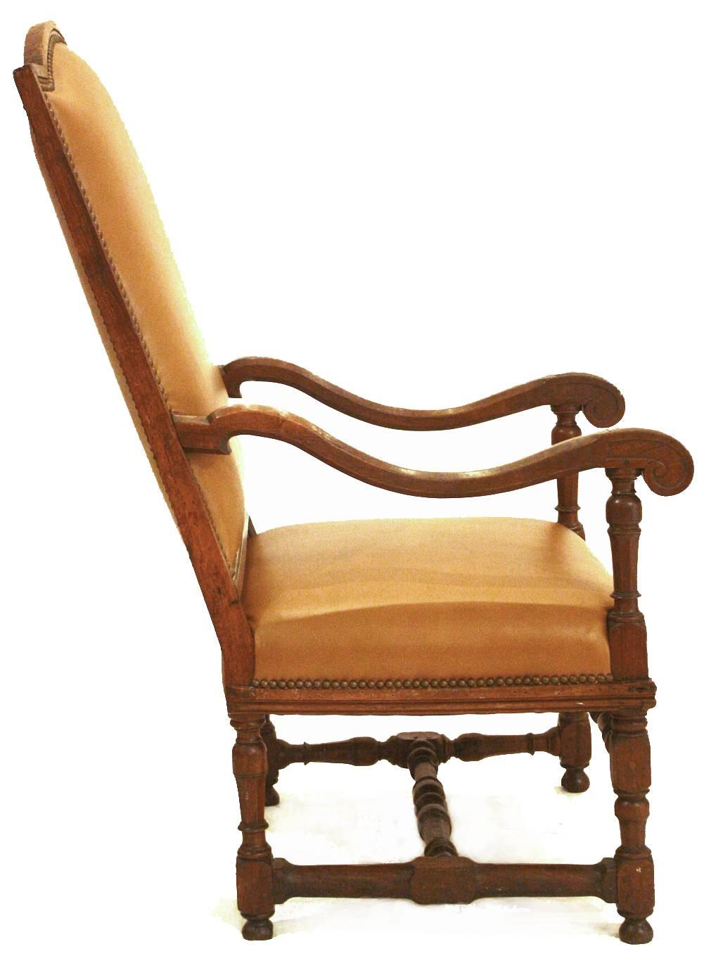 A large early 18th century Italian Baroque / Louis XIV-style high back armchair of walnut with shaped, curved arms and turned legs, front and rear, and turned stretchers, the chair has tall rectangular back with curved top, the whole newly