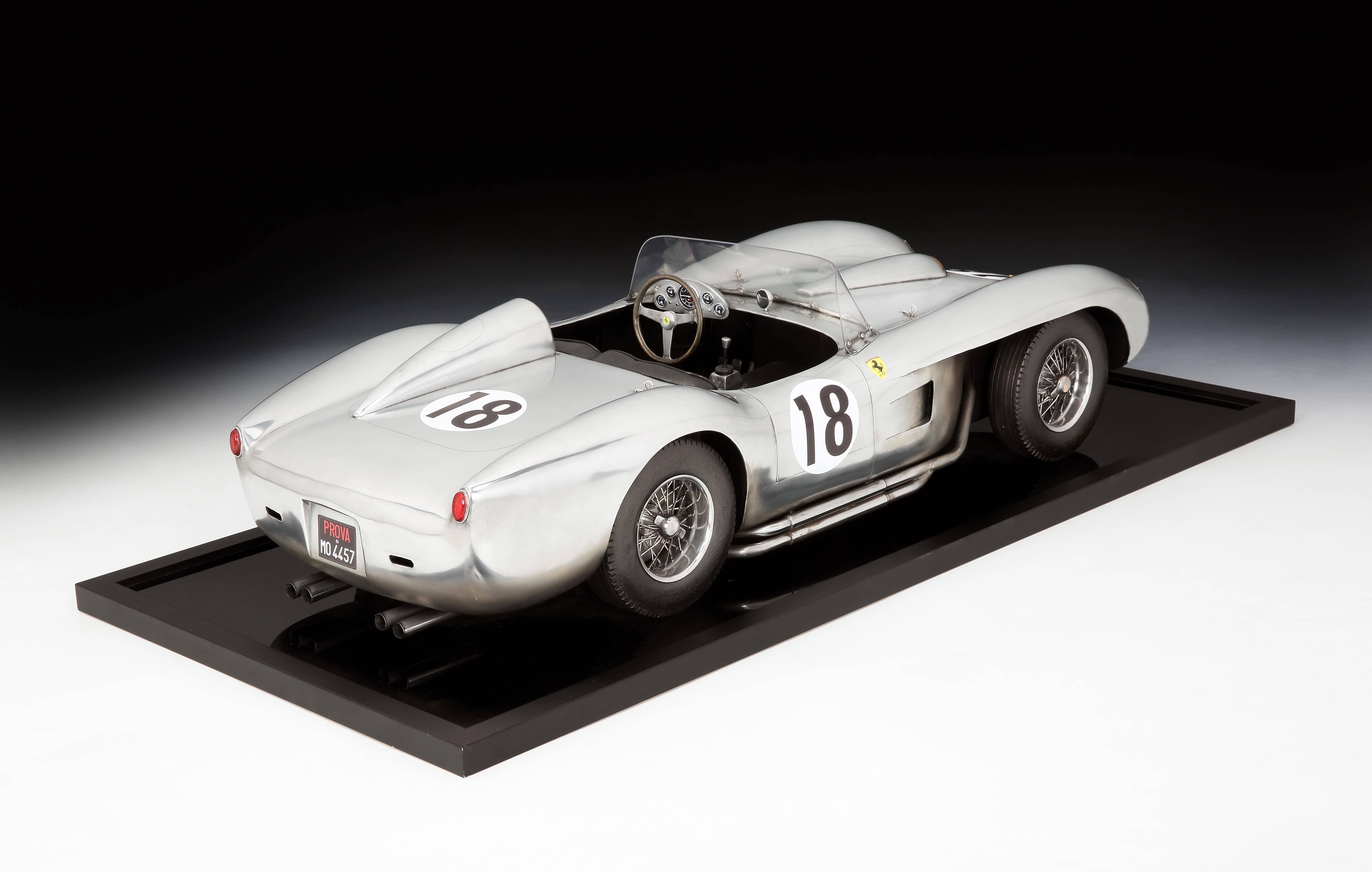 A powerful example of the car as art in the form of a large-scale model of the 1958 Le Mans winning Ferrari 250 (TR) Testa Rossa racing car, meticulously detailed in metal, leather and wood, with wire wheels and spinners, the body in formed aluminum